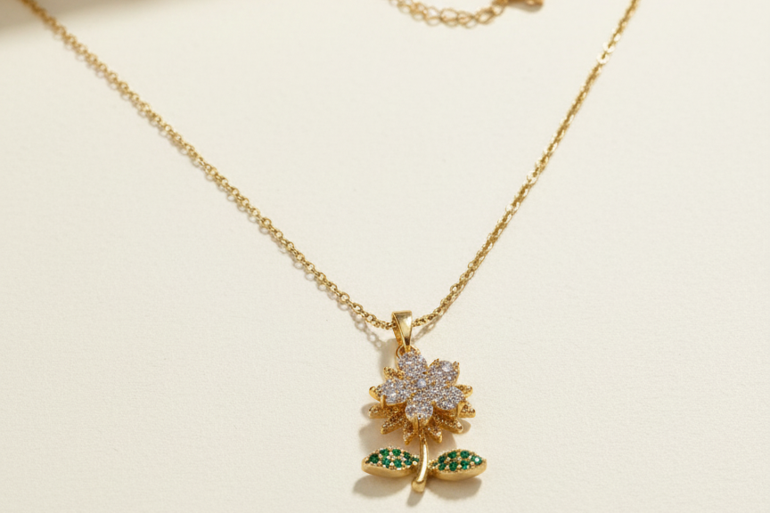 Gold necklace with a floral pendant on a beige background